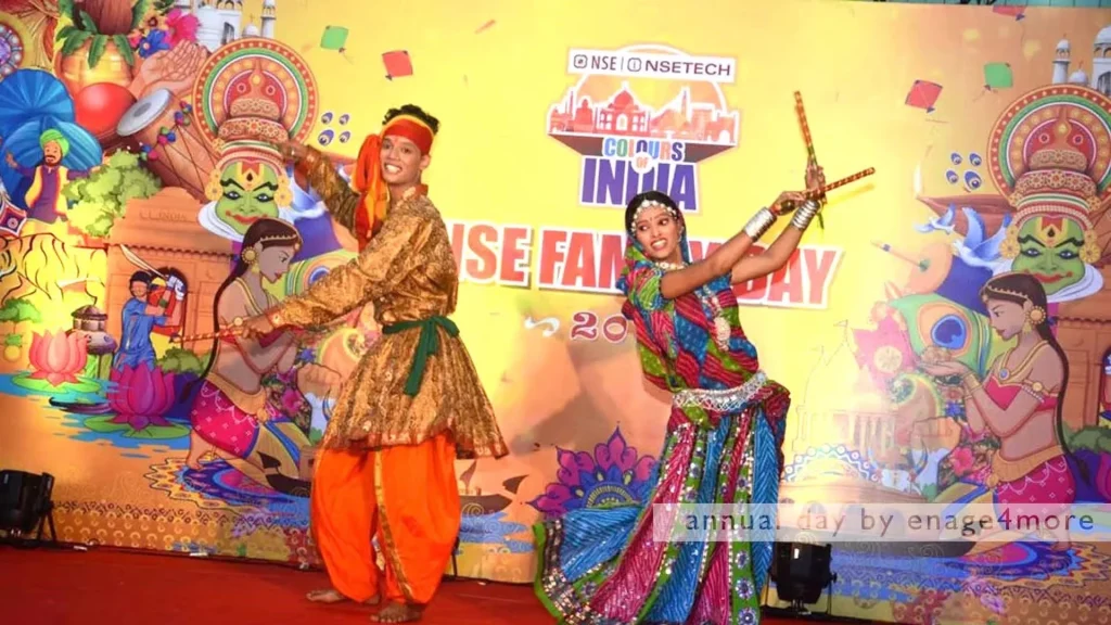 A man and woman in colorful traditional attire performing a folk dance with sticks in front of an "NSE Family Day" backdrop.