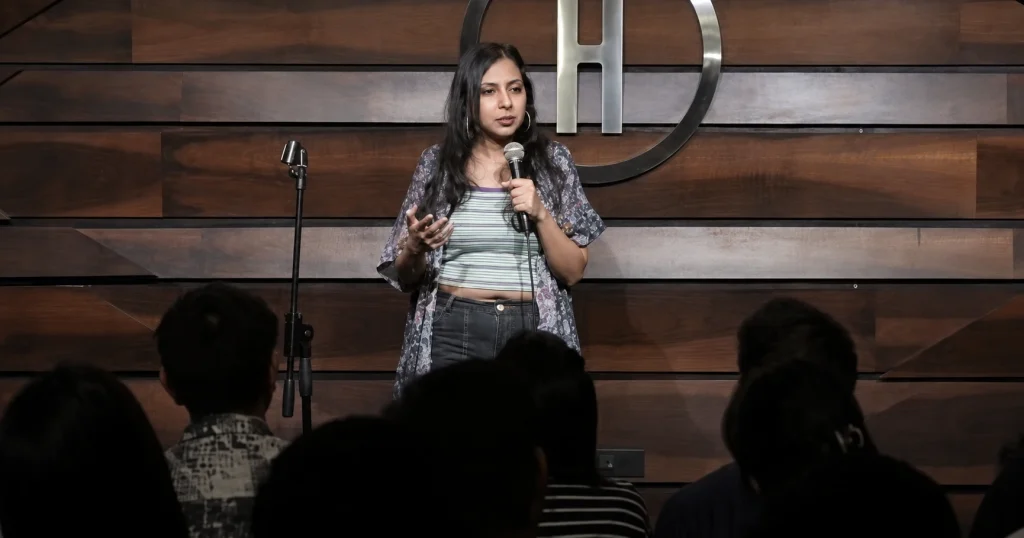 Indian stand-up comedian Agrima Joshua performing on stage before an audience