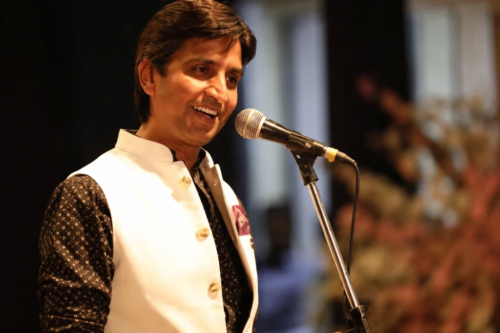 Renowned poet, performer, and Hasya Kavi Kumar Vishwas speaking into a microphone