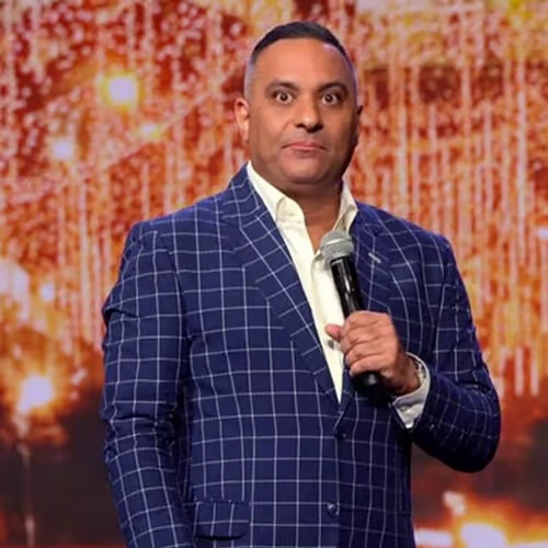 russell-peters-canadian-standup-comedian Canadian stand-up comedian Russell Peters performing on stage holding a microphone