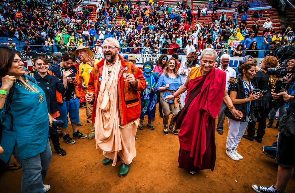 Dr. Saamdu Chetri dancing with others at a large public event, reflecting the spirit of community and Gross National Happiness