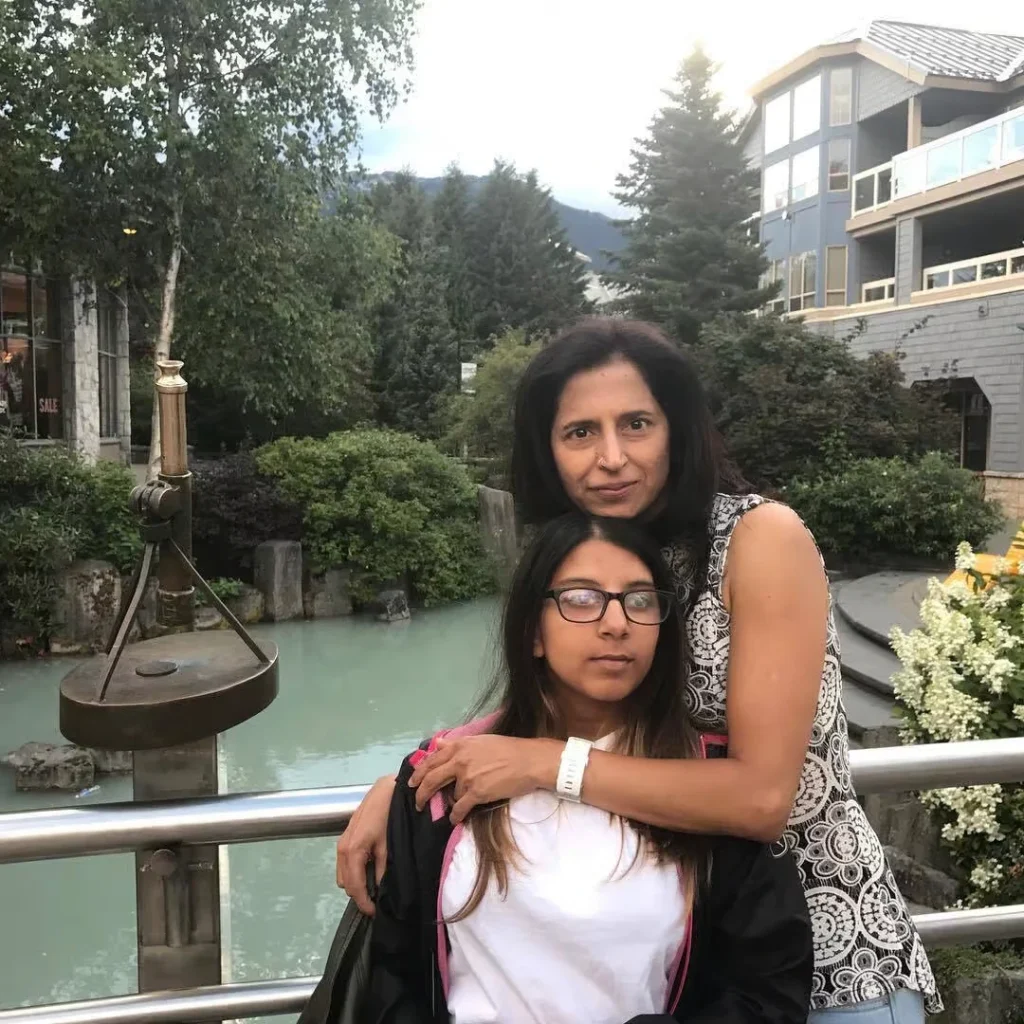 A candid photograph of Pooja Ruprell, author and corporate speaker, with a younger person outdoors