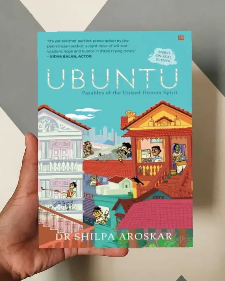 The book cover of Ubuntu: Parables of the United Human Spirit authored by pediatrician Dr. Shilpa Aroskar, held in a hand