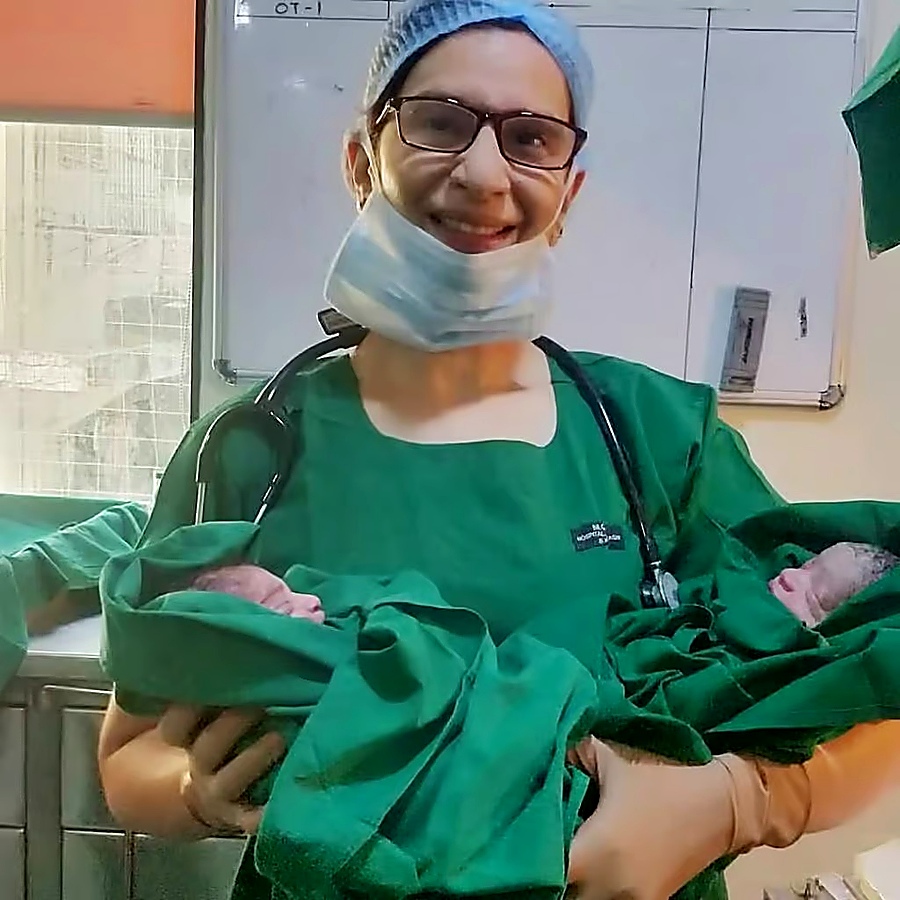 Dr. Shilpa Aroskar holding newborns in a clinical setting, representing her 25 years of pediatric expertise and wellness insights
