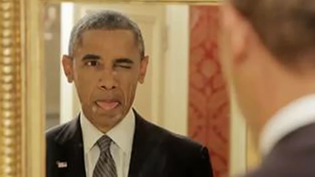 A candid reflection of Barack Obama in a mirror, winking and sticking his tongue out while dressed in a formal suit and tie.