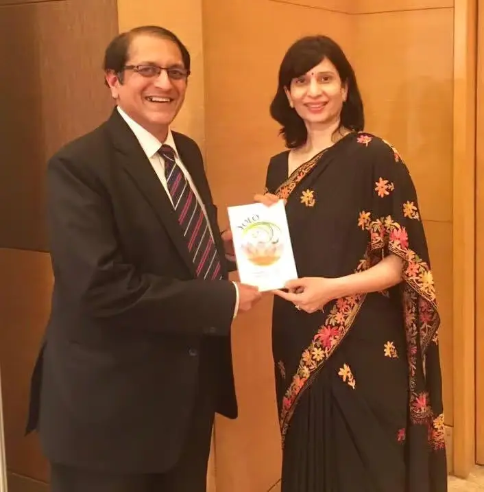 Dr. Shilpa Aroskar presenting her book YOLO, a collection of clinical stories from her practice, to a colleague