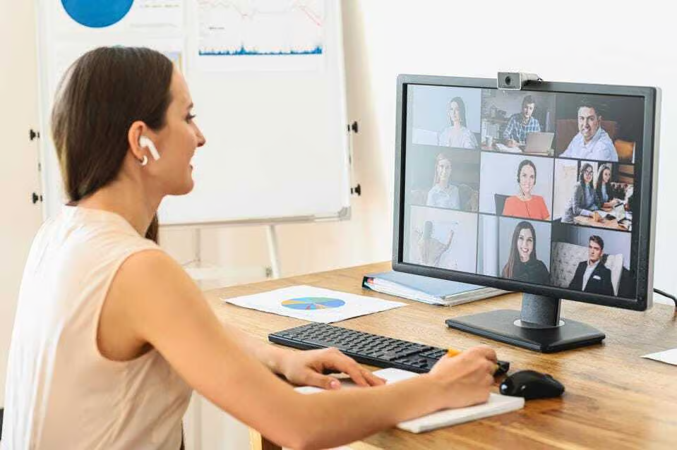 Corporate-On-Screen-Communication-Digital-Signage A wide-screen digital monitor mounted on an office wall displaying a colorful "Internal Communication" dashboard with various icons, charts, and progress bars, set against a modern office background.