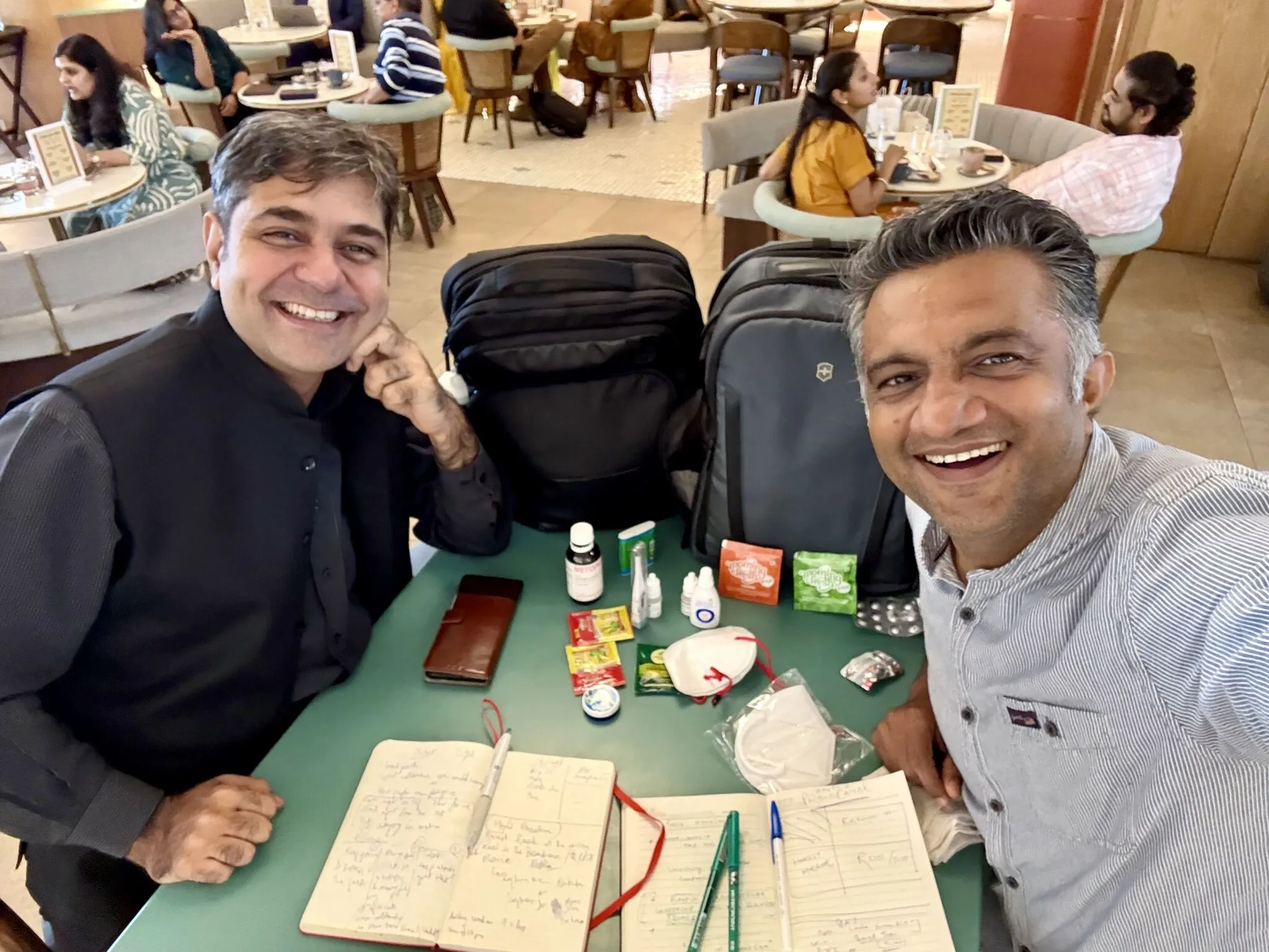 Trainer Rajen Makhijani & Nishant Parashar of engage4more brainstorming with their speaker survival kits and medical hacks laid out on a table.