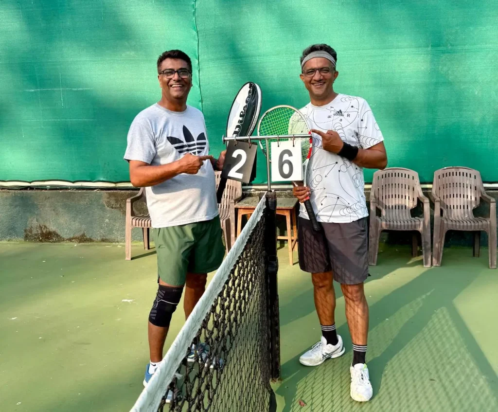 Nishant Parashar standing alongside a veteran professional tennis player in an indoor venue, representing high-level talent scouting and professional networking.