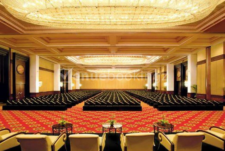 westin-powai-mumbai-grand-ballroom-corporate-event A wide-angle view of the massive, opulent Grand Ballroom at The Westin Mumbai Powai Lake, featuring intricate gold carpeting, tiered theater-style seating, and grand crystal chandeliers.