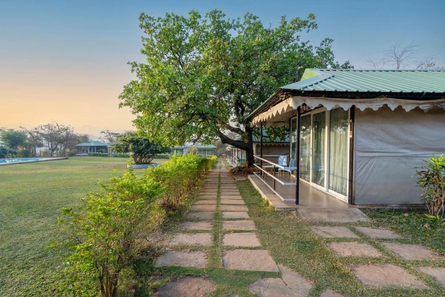 durshet-forest-trail-team-building-catapult-battle A scenic stone-paved nature trail at Durshet Forest Lodge, lined with rustic cottages and lush greenery, ideal for outdoor team building activities like Catapult Battle.