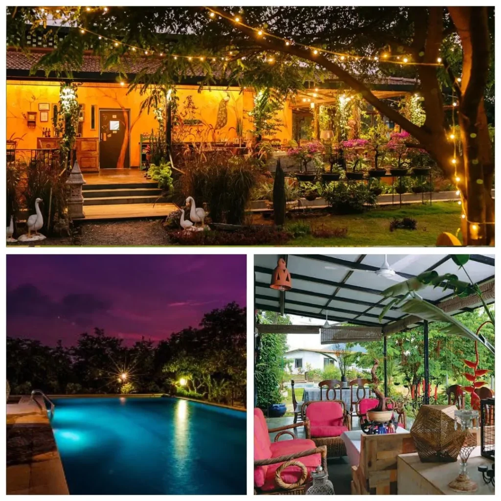 A warm, inviting view of the rustic yellow farmhouse at Tooth Mountain Farms, Karjat, decorated with fairy lights and surrounded by lush gardens at dusk