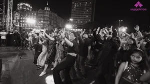 5 Best Corporate Offsite Destinations Near Mumbai for a 3-Day Strategy Retreat A high-energy black and white shot of a corporate team dancing at a night-time engage4more event with the Taj Mahal Palace and Gateway of India in the background.