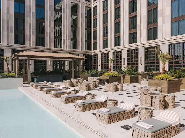 fairmont-mumbai-grand-aesthetic-corporate-venue A high-angle view of the luxury poolside terrace at Fairmont Mumbai, featuring elegant woven sun loungers and modern architectural facades.