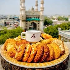 A plate of traditional Hyderabad Osmania biscuits and Irani Chai from Nimrah Cafe with the Charminar in the background