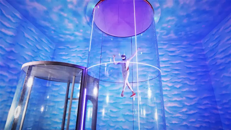 A corporate team member experiencing indoor skydiving at GravityZip Gandipet Hyderabad during an engage4more team building session.
