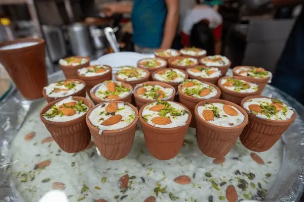 Traditional Kulhad Lassi topped with almonds and pistachios in Old Delhi, a popular spot for corporate team building food walks.
