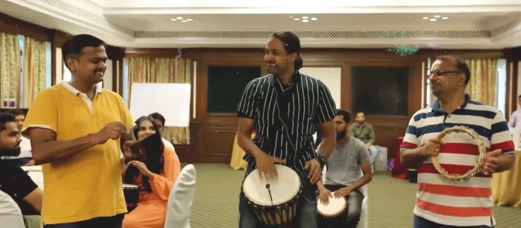 A group of employees participating in an interactive drum circle and music session facilitated by a professional.