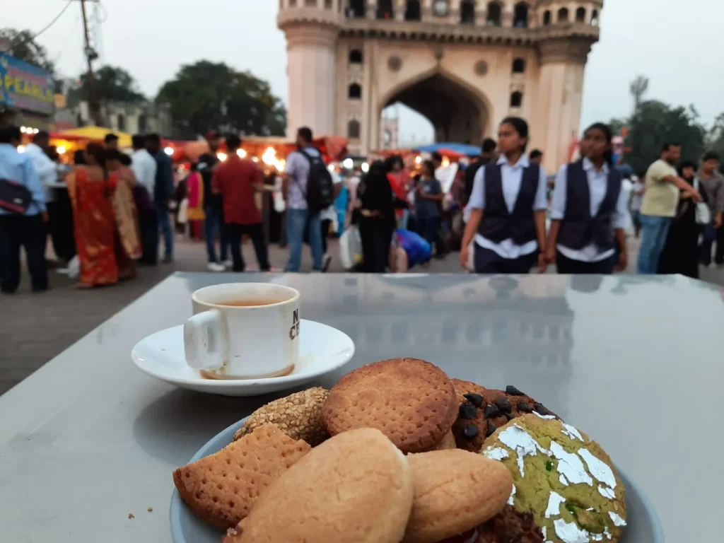 A plate of traditional Hyderabad Osmania biscuits and Irani Chai from Nimrah Cafe with the Charminar in the background